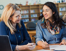 woman helping another woman with paperwork