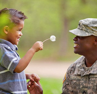Father in military fatigues with young son