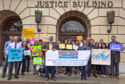 Group shot of the staff of the AG's office holding placards expressing appreciation